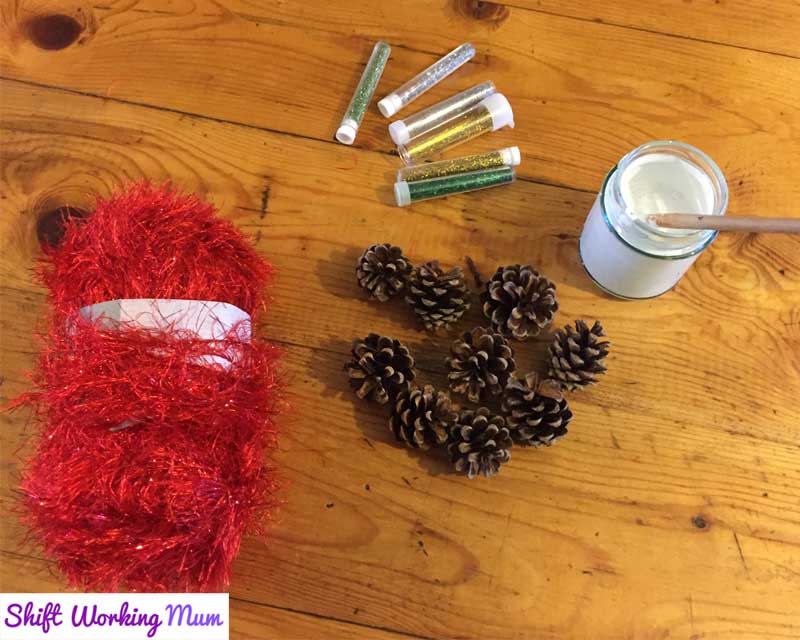 red sparkly wool, pine cones, glitter, white paint and PVA glue mix in a jar, paintbrush